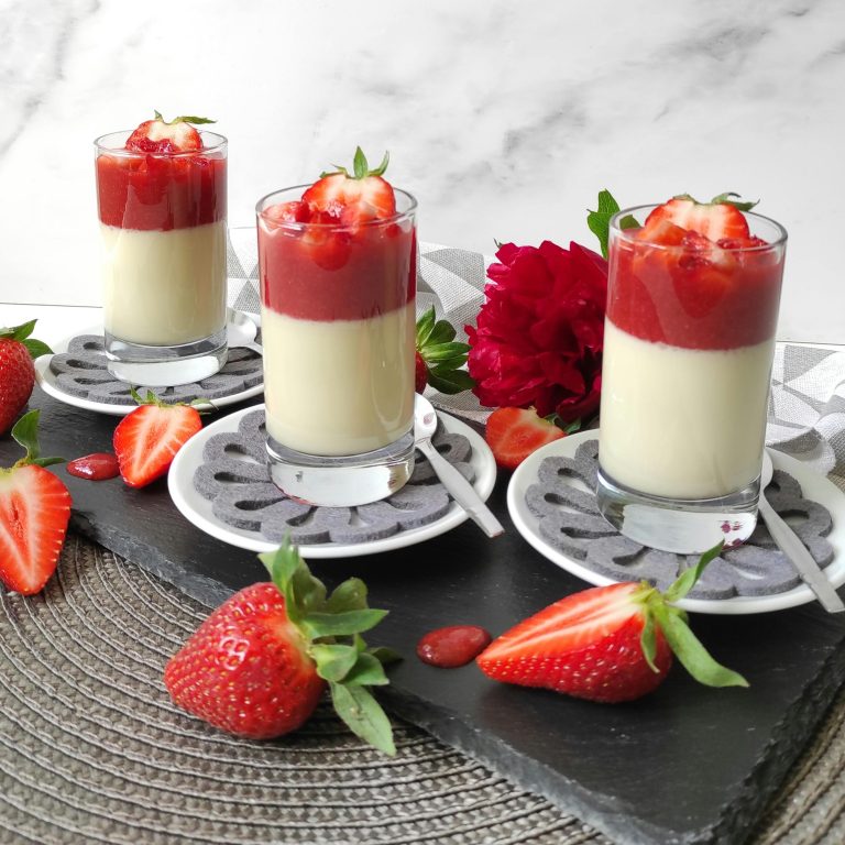 Image d'un verre de Crème onctueuse et sirop de fraises disposés en couches, un dessert élégant et appétissant.