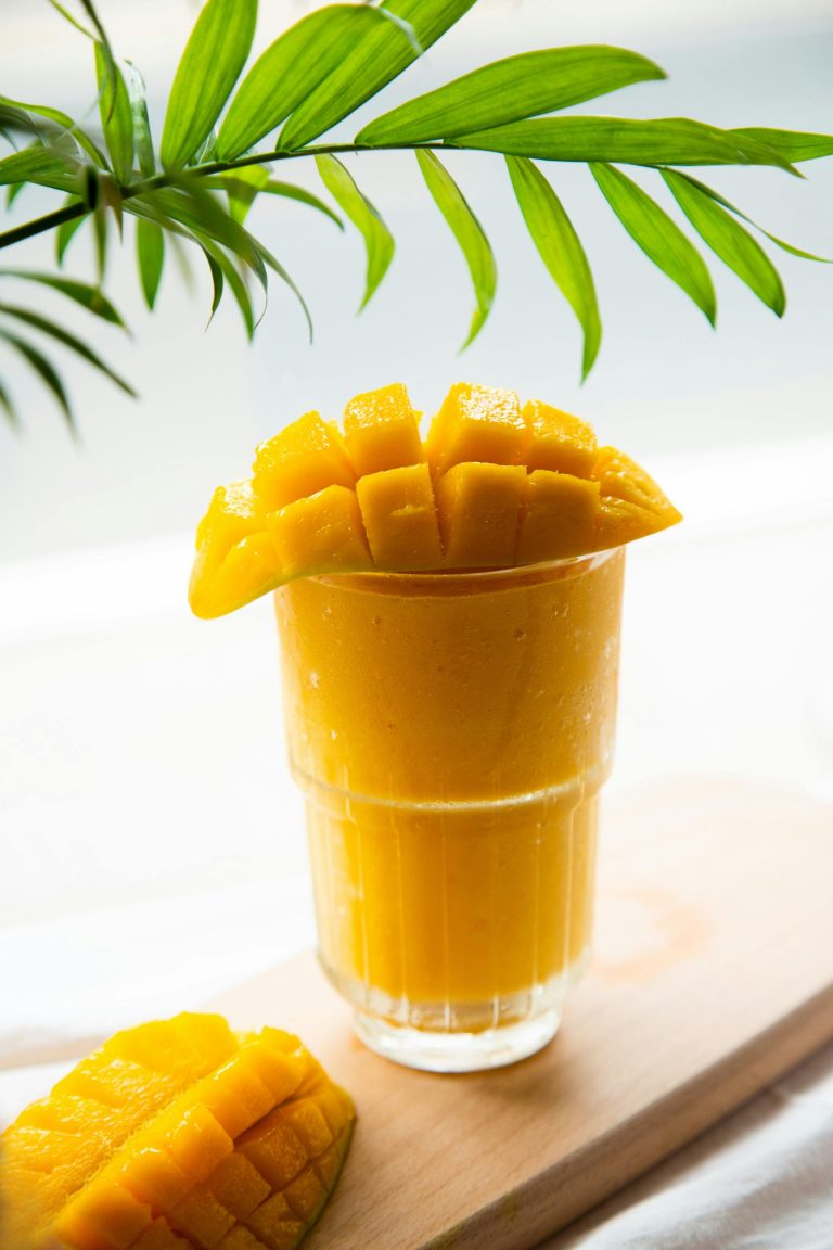 Image d'un verre de Smoothie à la mangue haïtienne, une boisson tropicale crémeuse et rafraîchissante